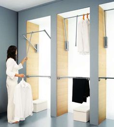 a woman standing in front of three closets with clothes hanging on the rail and two open doors