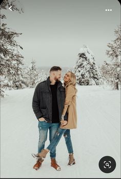 a man and woman are standing in the snow