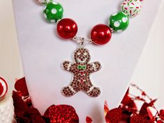 "Made with an adorable rhinestone Gingerbread Man pendant, this colorful and sparkly necklace is sure to make a little girl's eyes light up! A festive Christmas palette of red and green, along with Christmas sprinkles beads, is the perfect thing for Christmas baking. Makes a great stocking stuffer or Christmas present. Visit my Christmas section for more festive necklaces: https://www.etsy.com/shop/ChunkyStuffByLBB?section_id=16141299&ref=shopsection_leftnav_5 ✔ All necklaces come with a 2\" Christmas Holiday Necklace With Round Beads, Gift Rhinestone Beaded Necklaces, Gift Beaded Rhinestone Necklace With Round Beads, Gift Round Beads Bling Necklace, Gift Bling Round Beads Necklaces, Bling Round Beads Necklace For Gift, Gift Necklaces With Bling And Round Beads, Christmas Festive Jewelry With Rhinestones, Christmas Party Beaded Necklaces With Round Beads