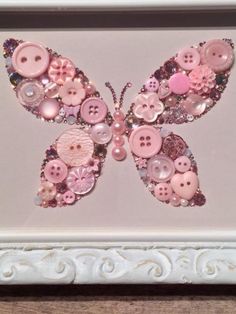 a white frame with pink buttons and a butterfly on it