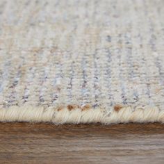 a close up view of a rug on a wooden floor with wood grained surface