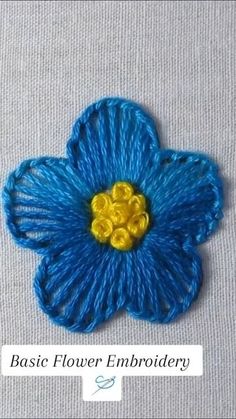 a blue flower with yellow center sitting on top of a table