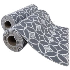 a grey and white patterned yoga mat with circles on the top, rolled up in half