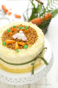 there is a cake decorated with carrots and other food items on the white plate