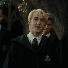 the harry potters are all dressed in black and white robes, one is wearing a green tie