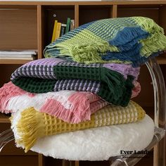 a stack of blankets sitting on top of a chair