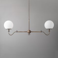 three lights are hanging from the ceiling in a room with gray walls and flooring