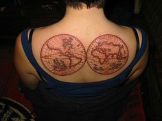 the back of a woman's shoulder with two tattoos on her shoulders and one in the shape of a world map