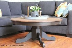 a living room with a gray couch and wooden coffee table in it's center