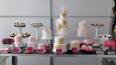 a table topped with lots of cakes and cupcakes