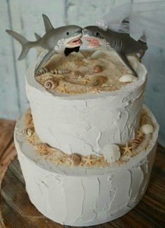 there is a cake that has two dolphins on the top and one fish on the bottom