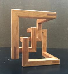 a small wooden sculpture sitting on top of a table next to a black countertop