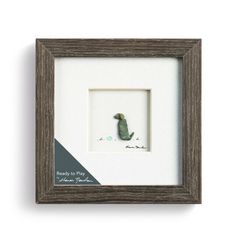 a framed photo with a small bird in the middle and a white frame above it