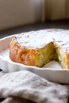 a cake is cut in half on a white plate with a cloth next to it