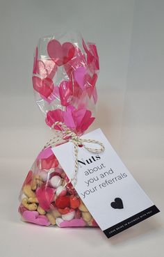 a bag filled with lots of hearts next to a tag that says nuts about you and your referals