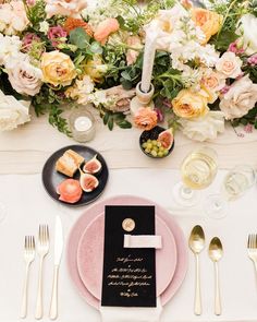 the table is set with pink plates and silverware