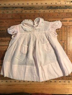 This is the most precious baby dress, pale pink cotton, with white lace and embroidered flowers on collar, and petite smocking on chest.  No tags, could be handmade, but if so by a highly skilled seamstress.  Sz. Is small 3-6 mo. I would say. Pink Cotton Collared Dress, Pink Collared Cotton Dress, Cute Pink Dress With Lace Collar, Vintage Smock Dress For Daywear, Cotton Smock Dress With Peter Pan Collar, Vintage Cotton Dress With Smocked Bodice, Pink Cotton Dress With Doll Collar, Vintage Short Sleeve Smock Dress, Vintage Smock Dress With Short Sleeves