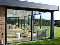 an open patio with chairs and tables on the grass