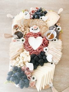 an assortment of cheeses and meats arranged in the shape of a bird on a table