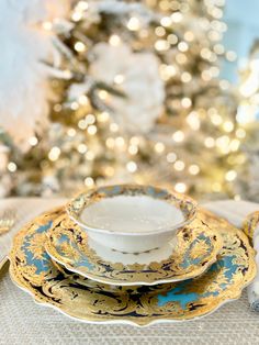 a christmas tree is in the background with gold and blue china on it, along with other holiday decorations