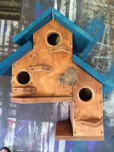 a wooden bird house with holes in the roof