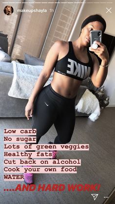 a woman taking a selfie with her cell phone while wearing leggings and a sports bra