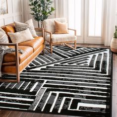 a black and white area rug in a living room with two chairs, a couch and a potted plant