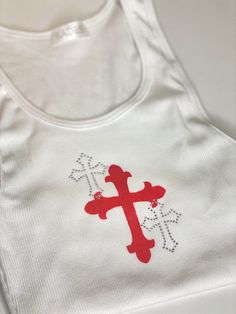 Details PREORDER- will be shipped within next two weeks! CUSTOM / HANDMADE Ribbed white tank top with custom hand painted cross and overlapping rhinestone cross embellishments. 100% Cotton Hand wash in cold water to preserve crystal placement Size & Fit One size Crystal Placement, Hand Painted Crosses, Top Paintings, Cross Shirts, Diy Cross, Crystal Cross, Rhinestone Cross, Cross Paintings, Custom Hand Painted