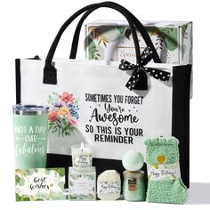 a white bag with black handles and some items in it that include candles, soaps, tea bags