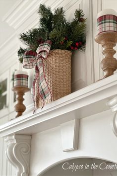 Basket of Christmas greenery with plaid bow next to two wooden candlesticks on white stove mantel. Kitchen Hood Decor, White Christmas Kitchen, Simple Christmas Mantel, Checked Curtains, Plaid Christmas Decorations, Cozy Christmas Aesthetic, Green And White Christmas, A Simple Christmas