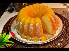 a bundt cake on a plate with powdered sugar and pineapples in the background