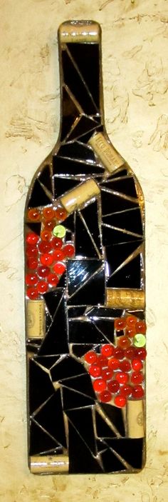 a bottle shaped like a mosaic with red and black flowers on it's side