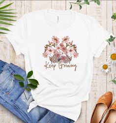 Keep Growing Flower Tshirt ✨Product Details * Gildan 18000 Unisex Crewneck Sweatshirt, not a Women's size! Please refer to the size chart for more details. * 50% cotton, 50% polyester * Light & Very comfortable fabric ✨Sizing and Coloring * Sweatshirts are true-to-size for UNISEX fit. * Fiber content of clothing may vary for different colors * Please make sure to select the correct size and color. * Please scroll through pictures to see the sizing chart for all measurements and information on si White Print T-shirt For Spring, Quote Tshirt, Motivational Tshirt, Keep Growing, Inspirational Tshirts, Growing Flowers, T Shirts With Sayings, Miami Fl, Text Design