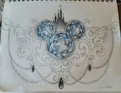 a drawing of mickey mouse's head with blue jewels on it and a castle in the background