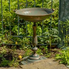 a bird bath sitting in the middle of a garden