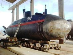 a large submarine sitting on top of a train track