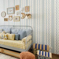 a day bed sitting in front of a wall with pictures on it and a teddy bear