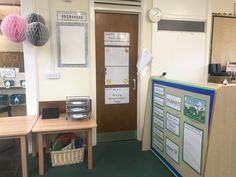 an office with two desks and a bulletin board