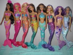 a group of barbie dolls standing next to each other