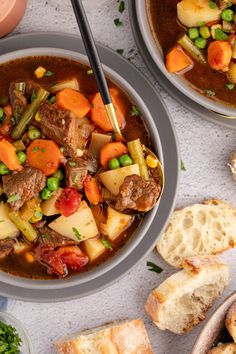 two bowls of stew with bread and vegetables