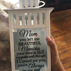 a person holding up a white candle holder with a poem on it that reads mom you left me beautiful memories, your love is still my guide and though i cannot see