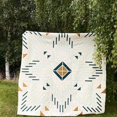 a large white quilt sitting on top of a lush green field