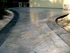 an outdoor patio with concrete walkways and landscaping