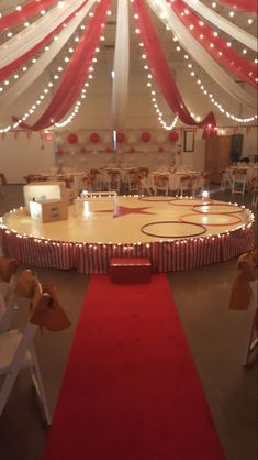 an indoor basketball court is decorated with red and white draping for the ceiling