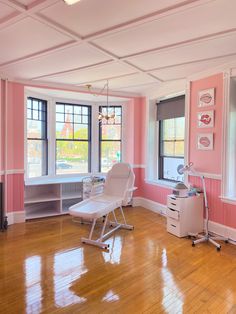 an empty room with pink walls and wooden floors