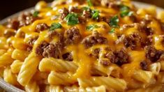 a plate filled with pasta covered in cheese and ground beef