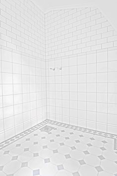 an empty white tiled bathroom with no shower curtain