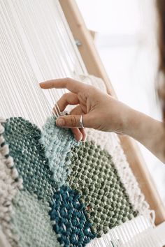 a woman is working on a weaving project