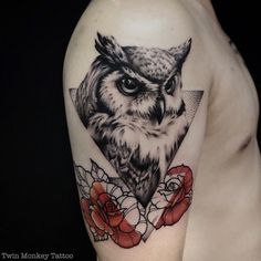 an owl tattoo with roses on the arm