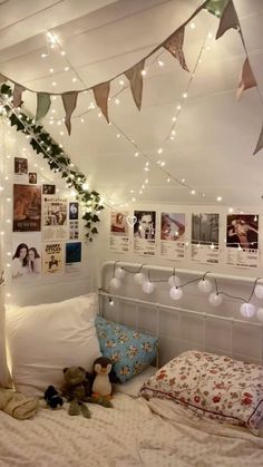 a bedroom with lights strung from the ceiling and pictures on the wall